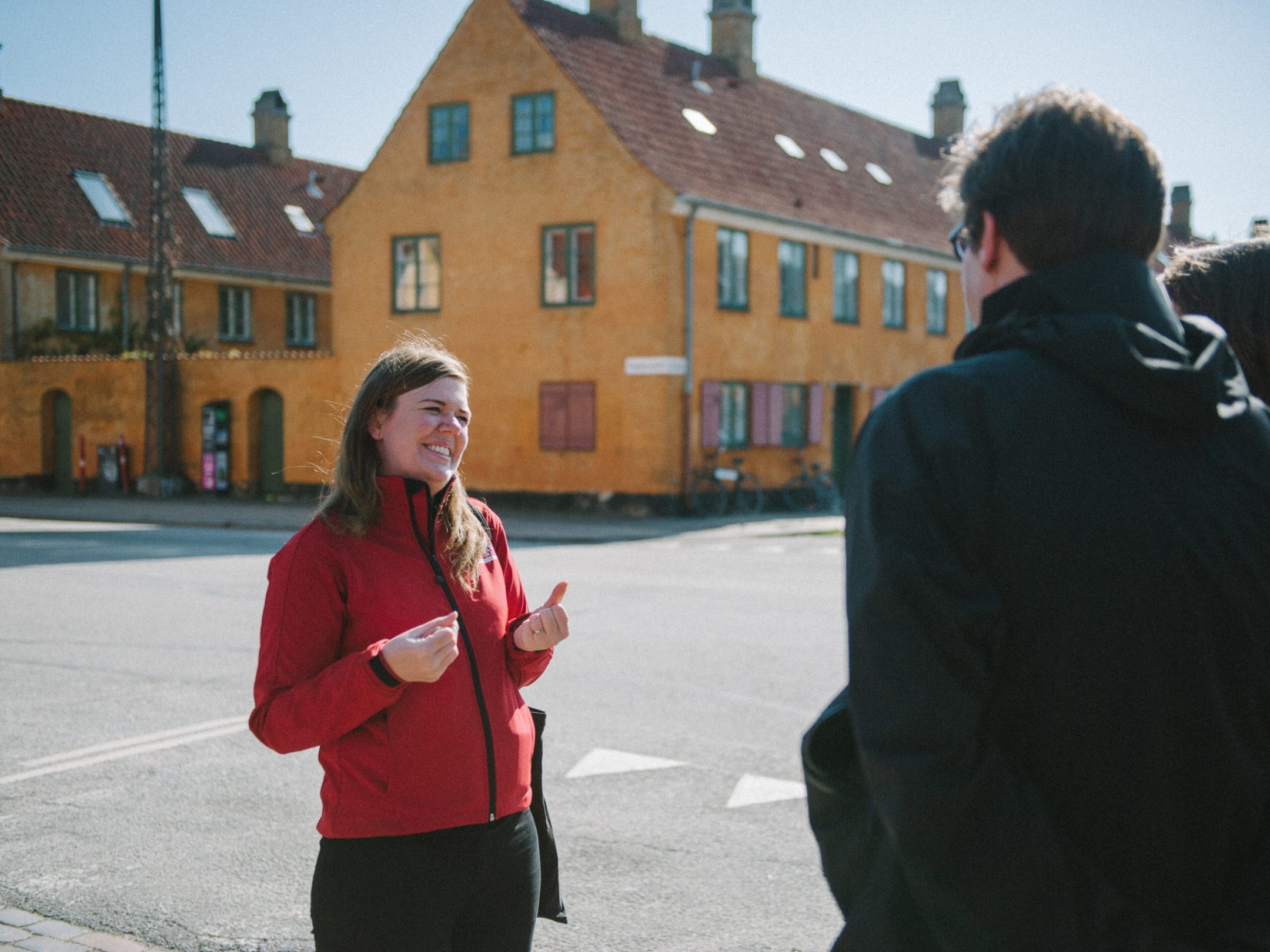 a man and a woman standing in front of a red building