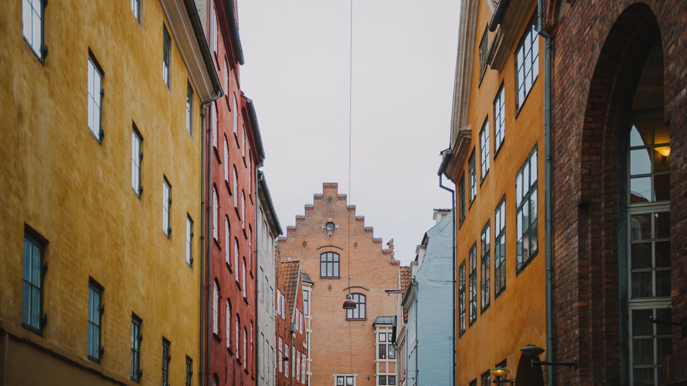 a large brick building with a clock on the side of the street